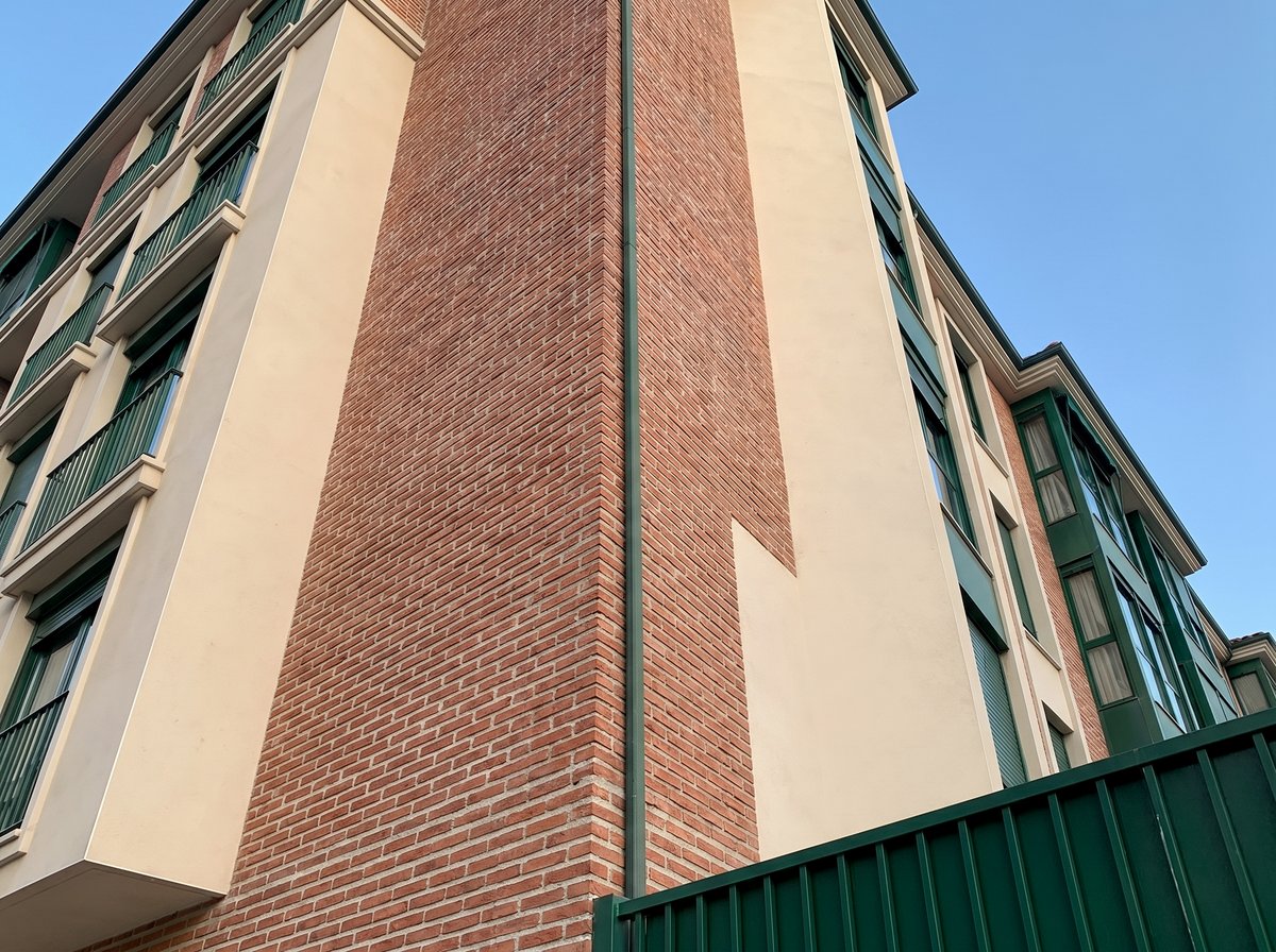 Esquinazo geométrico en ladrillo y estuco — Bloques Las Huertas, Zamora